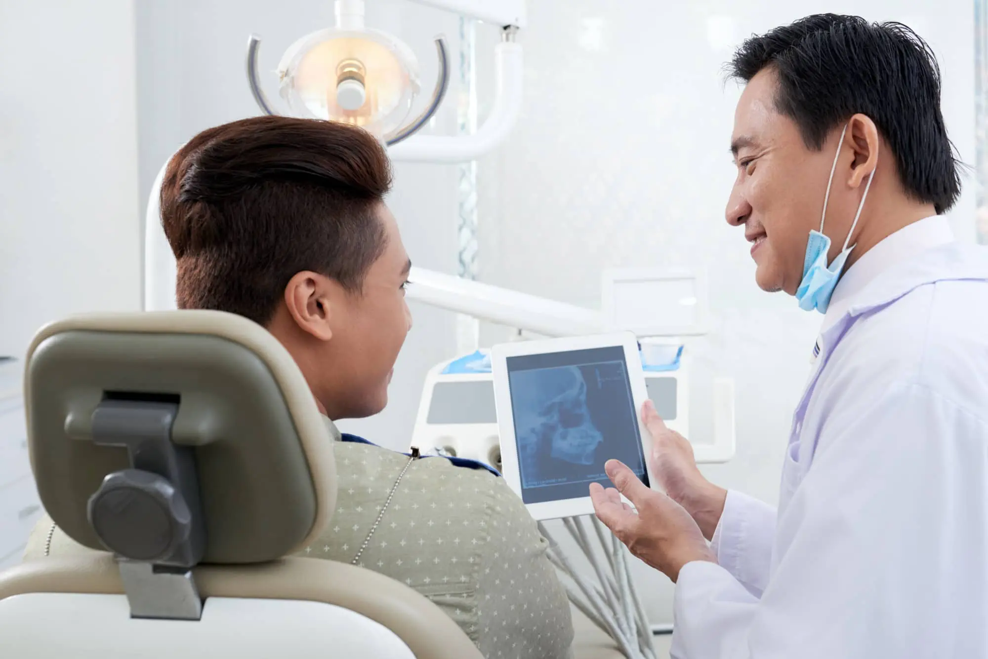 Orthodontist explaining how a palatal expander works to patient is seated in a dental chair at Redemption Orthodontics in Tallahassee, FL