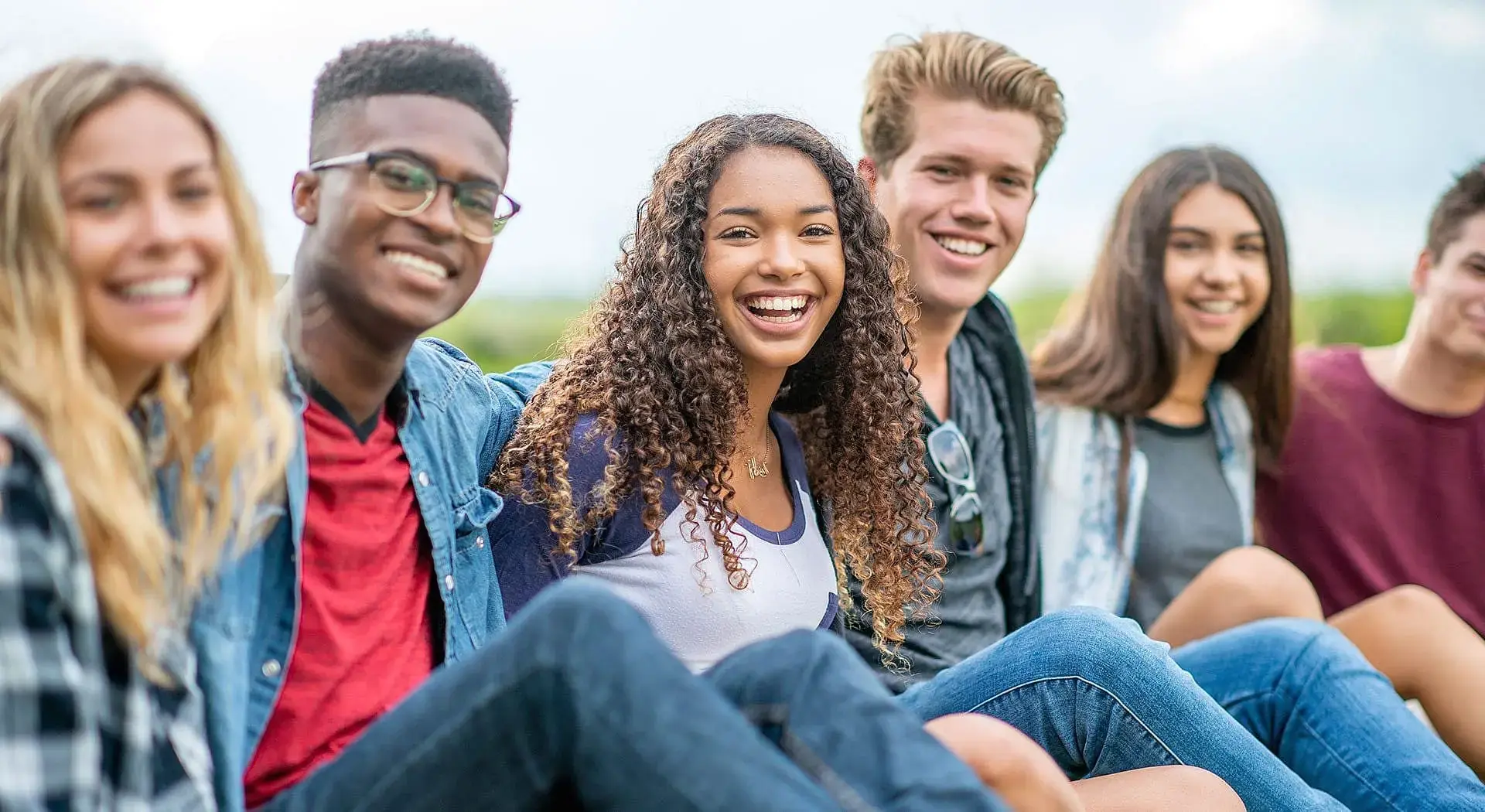 Six young adults smile at the camera outdoors on a sunny day after consider Invisalign vs Braces at Redemption Orthodontics in Tallahassee, FL. Six young adults smile at the camera outdoors on a sunny day after consider Invisalign vs Braces at Redemption Orthodontics in Tallahassee, FL.