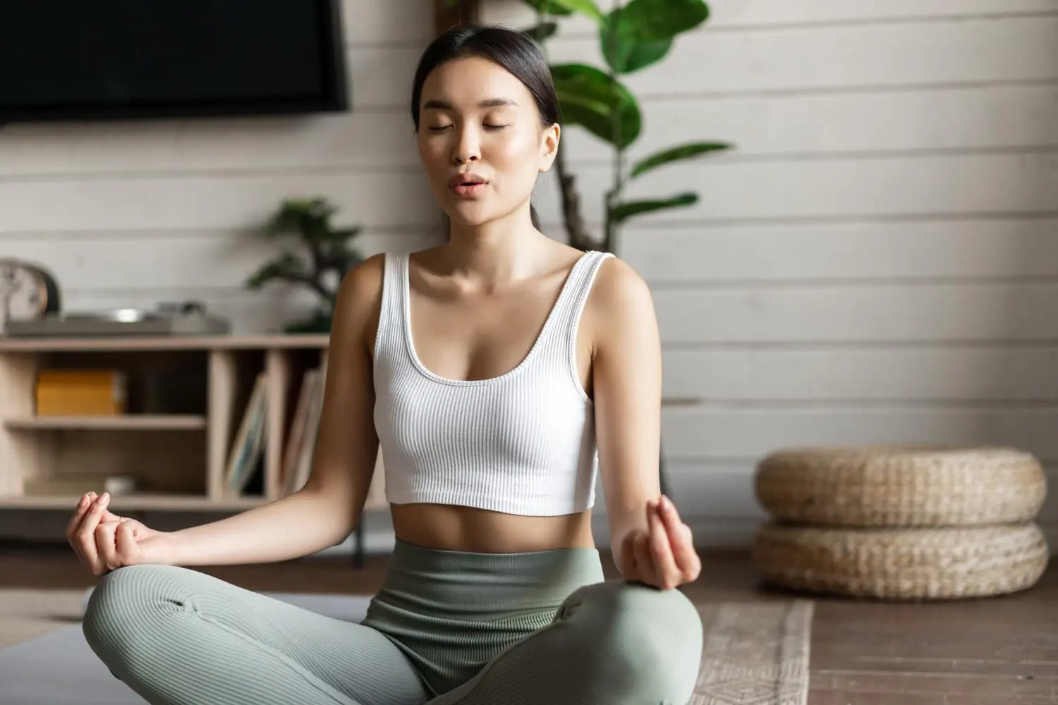 A woman meditating indoors, symbolizing wellness while highlighting the link between mouth breathing and oral health in Tallahassee, FL.