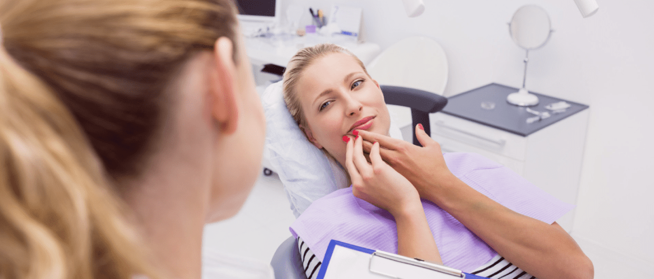 At Redemption Orthodontics in Tallahassee, FL, a woman in a dental chair discusses care with a professional holding a clipboard.